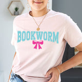 Person wearing a pink t-shirt with 'BOOKWORM' and a pink bow graphic.