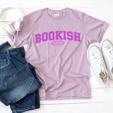 Lavender t-shirt with 'BOOKISH MAMA' text, paired with jeans and sneakers on a white surface.