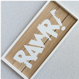 Wooden sign with 'RAVR!' in white letters on a light gray background