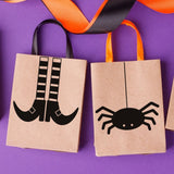 Halloween-themed paper bags with black designs on a purple background