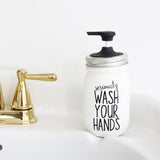 White soap dispenser with 'seriously wash your hands' text next to a gold faucet on a white background